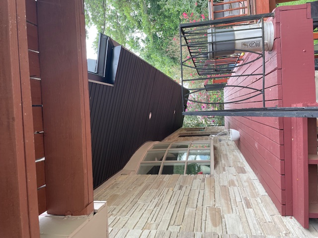 After: rebuilt covered porch with finished ceiling, beam and iron railing